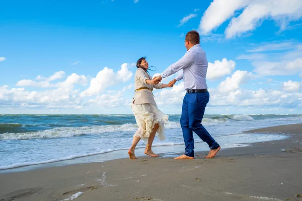 Glückliches Paar tanzt in der Nähe des winkenden Meeres — Stockfoto