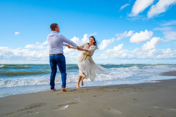 Glückliches Paar tanzt in der Nähe des winkenden Meeres — Stockfoto