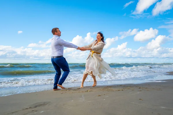 在海浪边跳舞的快乐夫妻 — 图库照片