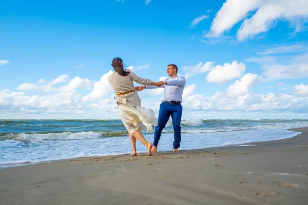 Casal feliz dançando perto do mar ondulando — Fotografia de Stock