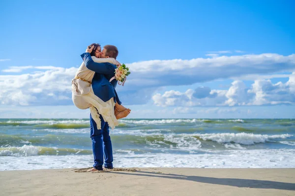 Noiva feliz e noivo abraçando na praia — Fotografia de Stock