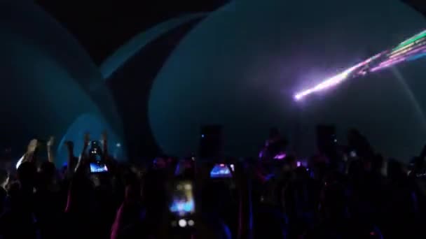 Luces de neón brillando sobre la multitud bailando — Vídeo de stock