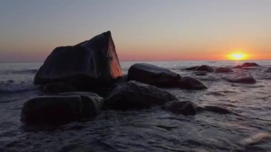 Dalgalı denizin üzerinde gün batımı gökyüzü