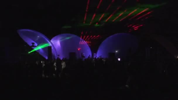 Над танцующей толпой сияют огни — стоковое видео