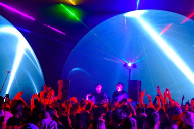 Parti boyunca kalabalık ve DJ 'ler dans ediyor.