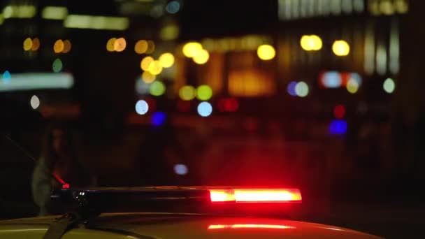 Şehirde yanıp sönen ışıkları olan polis arabası. — Stok video