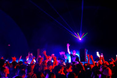 Parti boyunca kalabalık ve DJ 'ler dans ediyor.