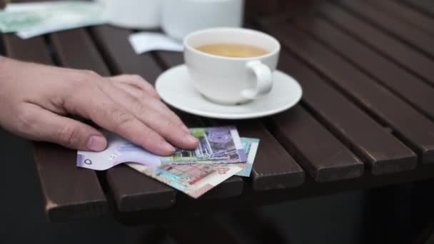Człowiek plon z pieniędzmi na tarasie w kawiarni — Wideo stockowe