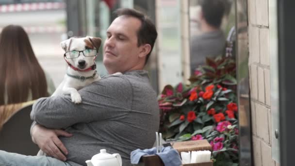 Medelålders man kramar hund i glasögon — Stockvideo