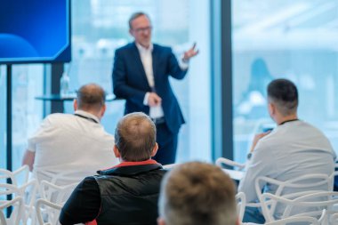 Profesyonel konuşmacı konferans ortamında seyirciye sunum yapıyor. İş ve öğrenim için ideal.