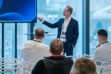 Modern konferans odasında izleyici ve konuşmacı ile iş sunumu işbirliği ve öğrenmeyi ön plana çıkarıyor.