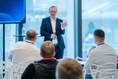 Modern ortamlarda katılımcı kitleye konuşma yapan profesyonel konuşmacı ile iş sunumu.