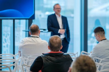 Modern ortamlarda katılımcı kitleye konuşma yapan profesyonel konuşmacı ile iş sunumu.