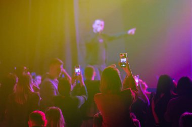 Seyirciler, canlı bir performansın canlı renkli ışıklarıyla atmosferdeki anlarını yakalıyor.