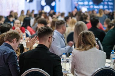 Çeşitli profesyonellerin katıldığı şirket etkinliği pozitif atmosferi olan modern bir mekanda seminere katılıyor.