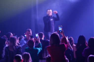 İzleyiciler canlı atmosferdeki sahne ışıklarıyla aydınlatılan akıllı telefonlarla canlı müzik performansını kaydediyorlar..