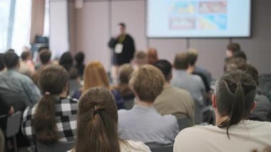 Bir konferans odasında izleyicilere sunum yapan profesyonel ayarlar.