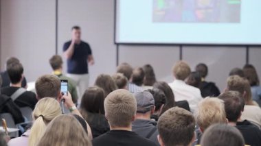 Dinleyiciler modern konferans ortamında yapılan eğitim oturumunda dikkatle konuşmacıları dinliyor