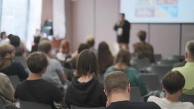 Bir konferans odasında izleyicilere sunum yapan profesyonel ayarlar.