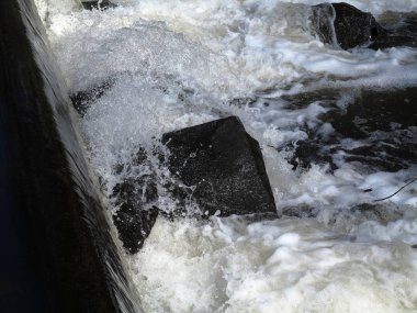 River Rapids - Köpüklü sular siyah kayaların arasından hızla akar