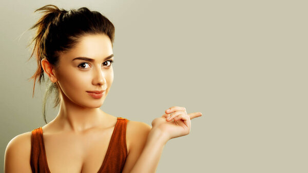 Молодая женщина указывает пальцем, чтобы скопировать текстовое пространство
