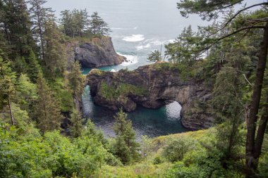 Oregon sahili, kilometrelerce beyaz kumlu plaj, deniz yığınları ve okyanus dalgaları.