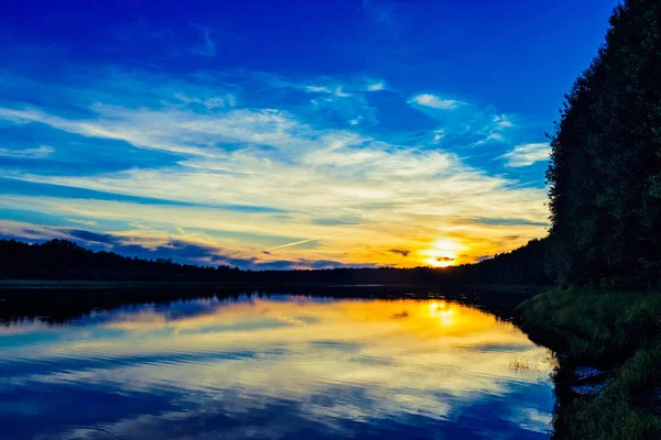 Západ slunce v oblacích nad jezerem — Stock fotografie