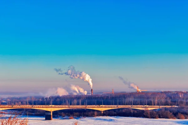 Industrial landscape with a bridge over the river in winter — Stock Photo, Image