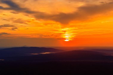 bulutların üzerinde uzak tepeleri nde günbatımı