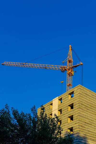 Building crane and residential house under construction — Stock Photo, Image