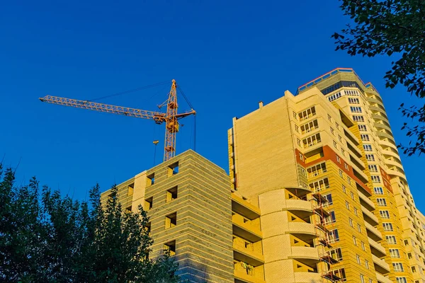 Building crane and residential house under construction — Stock Photo, Image