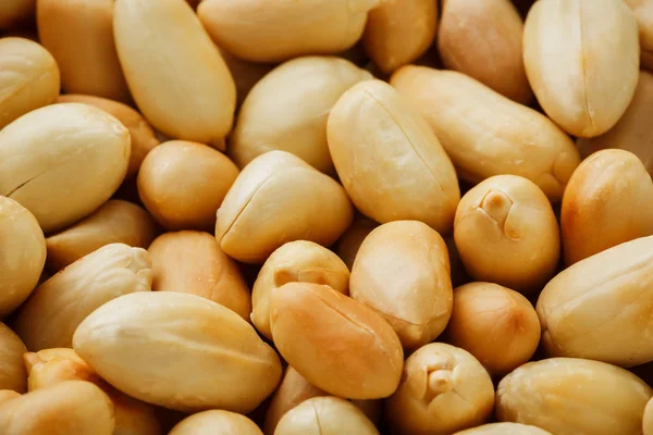 Peanut texture. Food background of peanuts bean. Golden, roasted organic peanuts. Wholesome organic legumes. Close-up, macro.