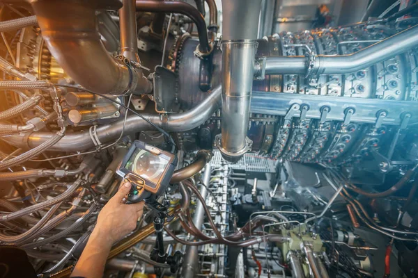 Inspection of a gas turbine engine using a Video Endoscope. Search for defects inside the turbine and shooting on video, photos using a measuring instrument. Gas turbine engine of feed gas compressor located inside pressurized enclosure, The gas turb