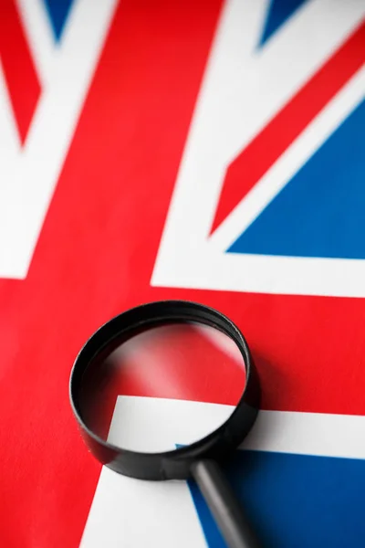 UK flag looking through a magnifying glass. Spying and observing England. Monitoring the state of Britain The concept of the danger of theft of military terrorism