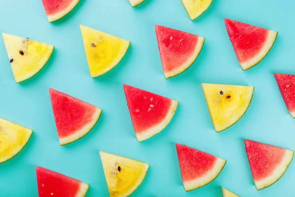 Slices of fresh slices of yellow and red watermelon on a blue background. View from above