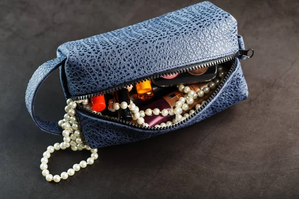 Bag for cosmetics and jewelry made of genuine dark blue leather, on a dark background. Handwork
