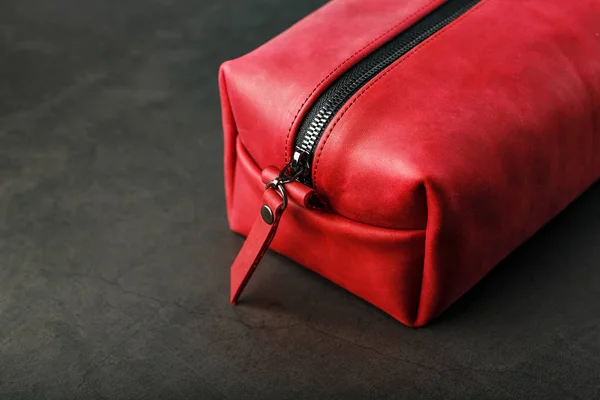 Bag for cosmetics and jewelry made of genuine red leather, on a dark background. Handwork.