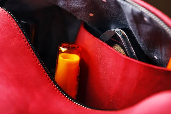 Bag for cosmetics and jewelry made of genuine red leather, on a dark background. Handwork, View from above