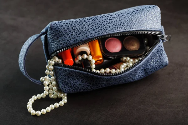 Bag for cosmetics and jewelry made of genuine dark blue leather, on a dark background. Handwork