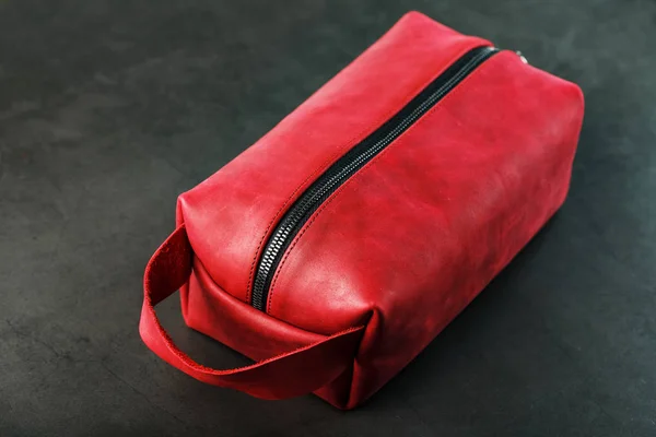 Bag for cosmetics and jewelry made of genuine red leather, on a dark background. Handwork.