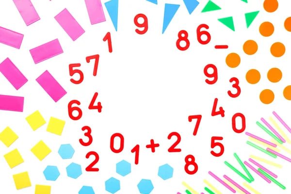 Multicolored plastic figures and numbers on a white background. The view from the top Educational games for children. Math and calculation skills.