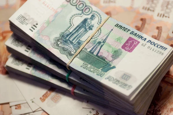 其他钞票背景上的一捆钞票 1000卢布和5000卢布 免版税图库照片