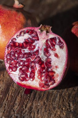 Koyu renk ağaçta üç tane nar. 