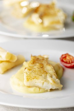 Tabakta kızarmış morina balığı. 