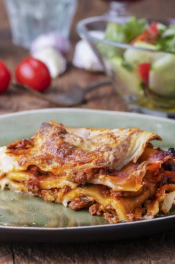 Yeşil bir tabakta pişmiş lazanya. 