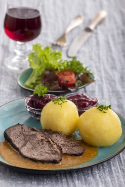 german sauerbraten on a plate with dumplings  clipart