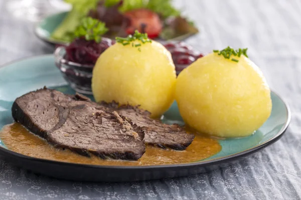 Alman Sauerbraten 'ı köftelerle dolu bir tabakta 