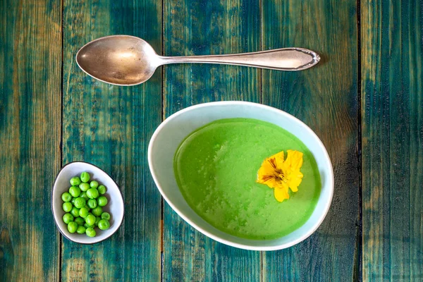 creamy pea soup on green wood