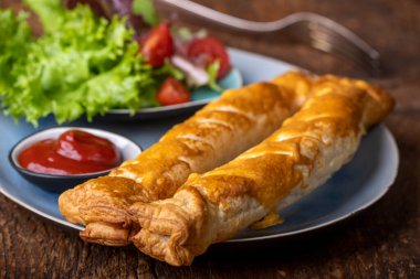 Bir tabakta sosisli börek.