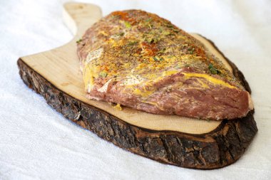 Doğranmış bir tahtanın üzerinde marine edilmiş et.